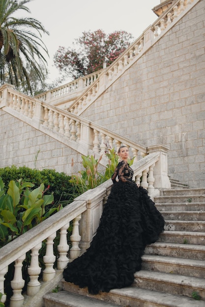 Foto mooie jonge vrouw in een luxe zwarte jurk in montenegro