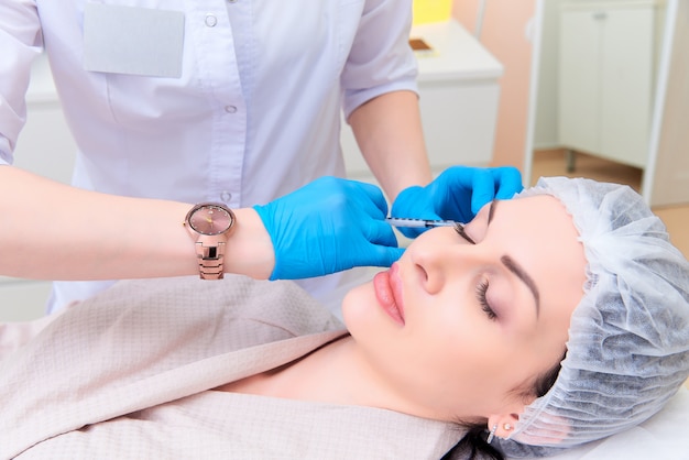 Mooie jonge vrouw in esthetische kosmetiekkliniek.