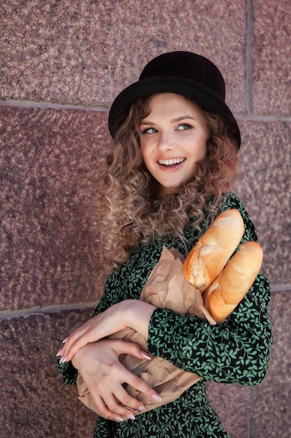 Mooie jonge vrouw in Franse stijl met baguettes in handen