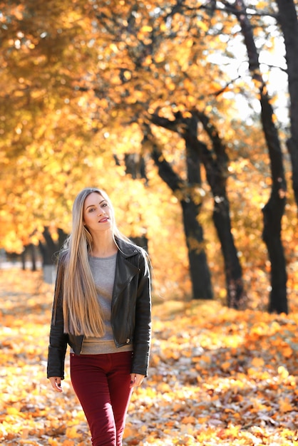 Mooie jonge vrouw in herfst park op zonnige dag