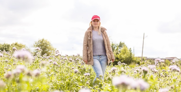 Mooie jonge vrouw in paarse bloemen buitenshuis