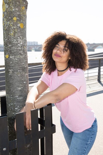 mooie jonge vrouw in roze t-shirt met krullend haar