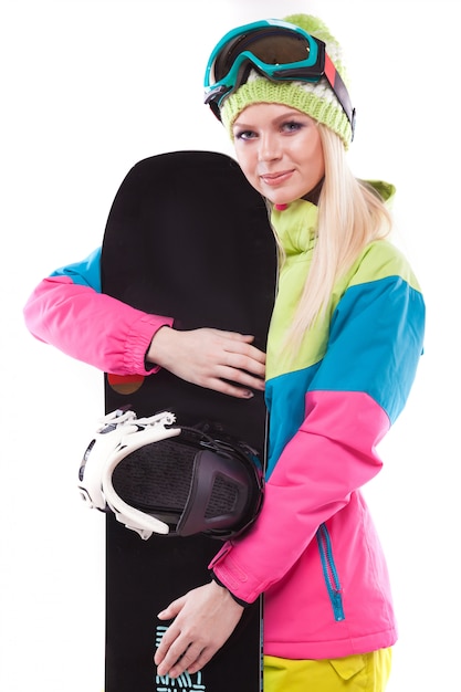 Mooie jonge vrouw in ski-outfit en ski bril houden snowboard