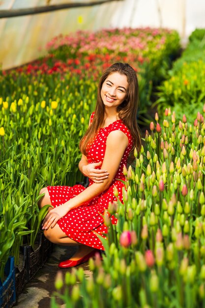 Mooie jonge vrouw in tulpenveld in de kas