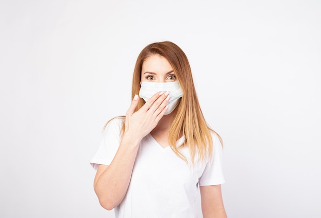 Mooie jonge vrouw in wit t-shirt met wegwerp gezichtsmasker