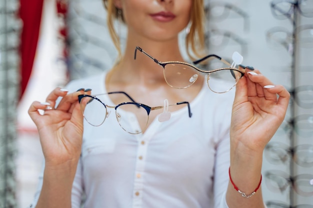 Mooie jonge vrouw kiest nieuwe bril bij optiekwinkel Gezichtscorrectie Oogheelkunde