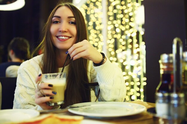 Mooie jonge vrouw koffie drinken in café. tonned