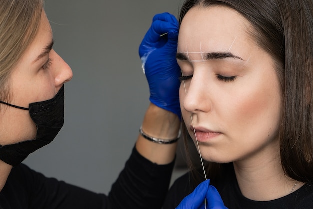 Mooie jonge vrouw krijgt wenkbrauw correctie procedure.