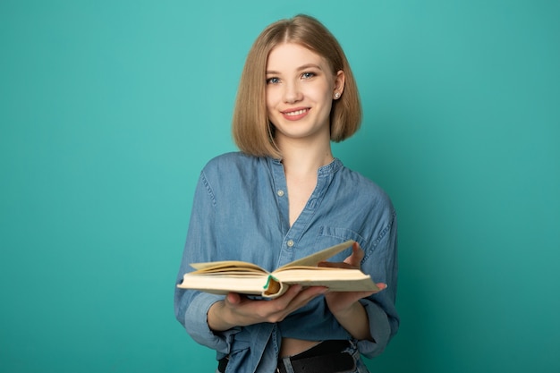 mooie jonge vrouw leesboek op blauwe achtergrond