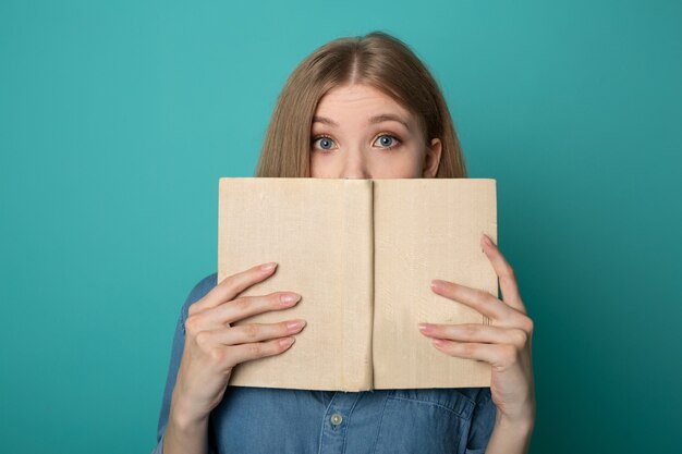 mooie jonge vrouw leesboek op blauwe achtergrond