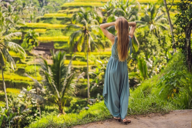 Mooie jonge vrouw lopen op typisch Aziatische heuvel met rijst landbouw bergvorm groene cascade rijstveld terrassen rijstvelden Ubud Bali Indonesië Bali reisconcept