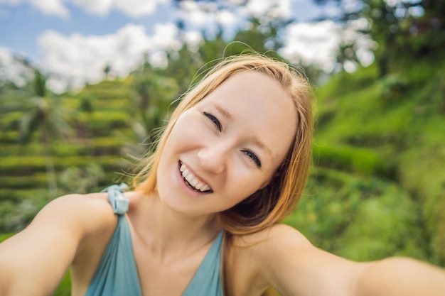 Mooie jonge vrouw lopen op typisch Aziatische heuvel met rijst landbouw bergvorm groene cascade rijstveld terrassen rijstvelden Ubud Bali Indonesië Bali reisconcept