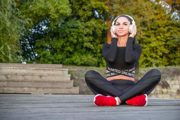 Mooie jonge vrouw luistert naar muziek./Fitness vrouw luistert naar muziek met een koptelefoon.