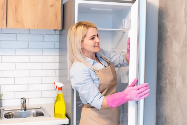 Mooie jonge vrouw maakt het huis schoonmaken. Meisje wrijft stof.