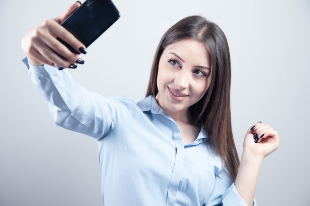 Mooie jonge vrouw maakt selfie foto met smartphone.