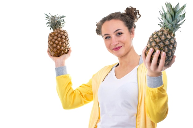 Mooie jonge vrouw met ananas op wit wordt geïsoleerd