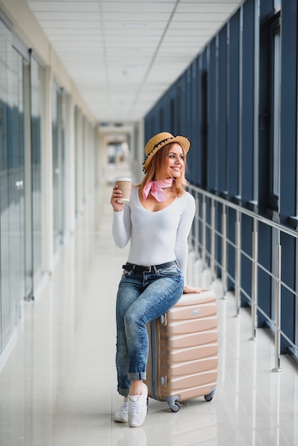 Mooie jonge vrouw met bagage op de luchthaven