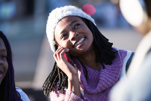 Foto mooie jonge vrouw met behulp van haar mobiele telefoon in de straat.