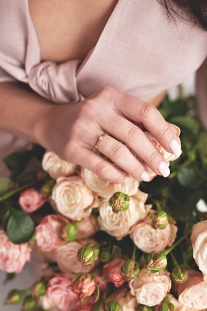 Mooie jonge vrouw met boeket bloemen van rozen Internationale Vrouwendag