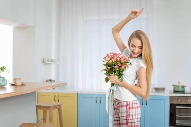 Mooie jonge vrouw met boeket rozen thuis