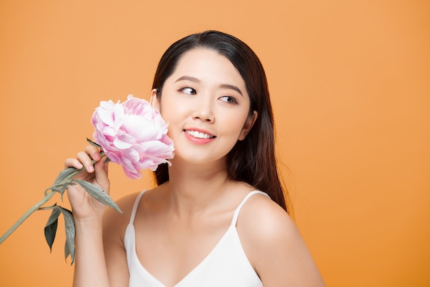 Mooie jonge vrouw met delicate pioenroos.