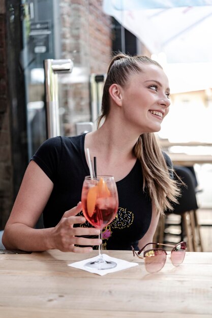 Foto mooie jonge vrouw met drankje aan de bar