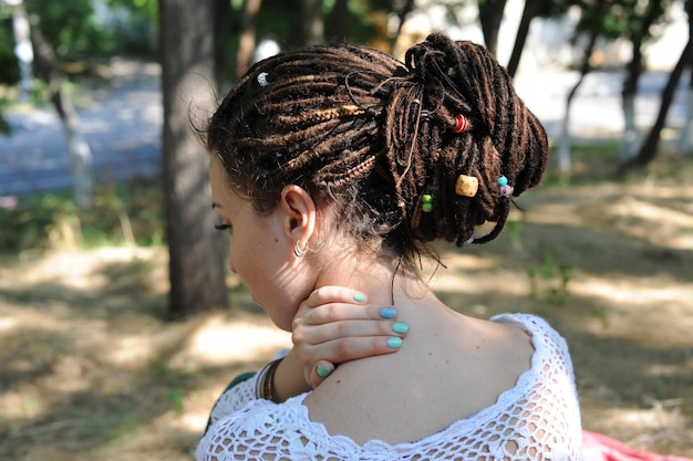 Foto mooie jonge vrouw met dreadlocks kapsel verzameld in een paardenstaart versierde diverse kralen