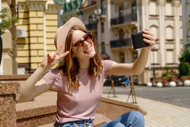 Mooie jonge vrouw met een hoed die een selfie neemt