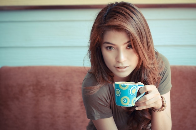 Mooie jonge vrouw met een koffiekopje van een café