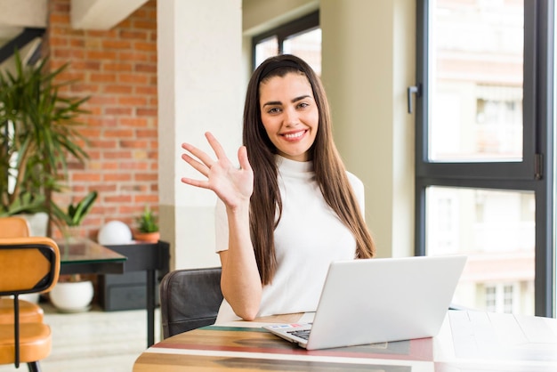 Mooie jonge vrouw met een laptop die thuis werkt huis interieur ontwerp