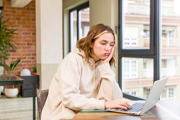 Mooie jonge vrouw met een laptop die thuis werkt huis interieur ontwerp