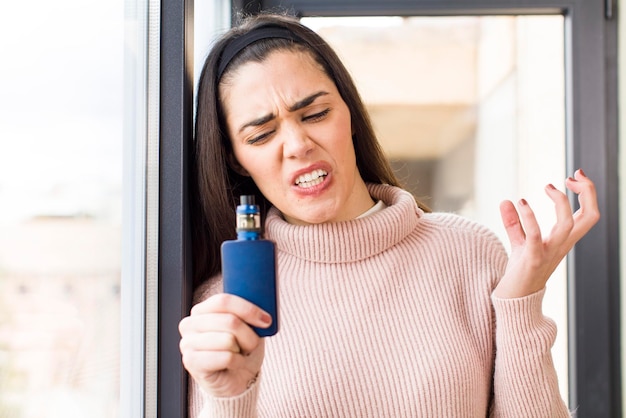 Mooie jonge vrouw met een vaper huis interieur