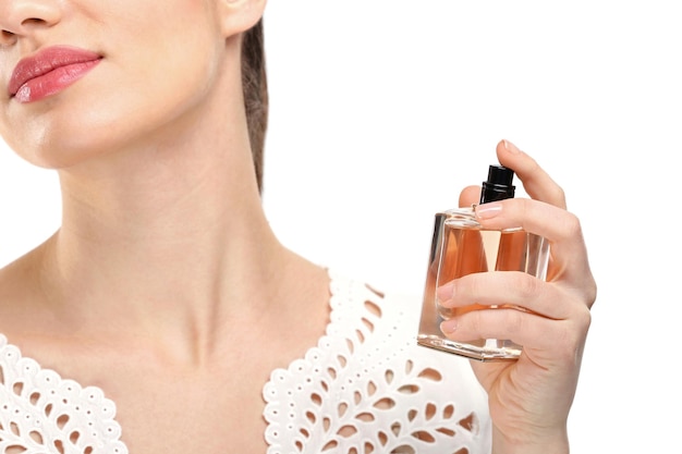 Mooie jonge vrouw met fles parfum op witte achtergrond