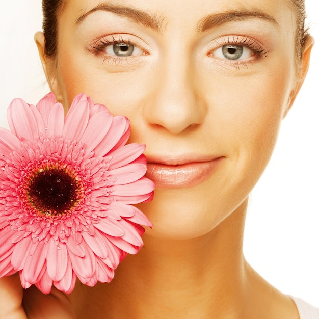 Foto mooie jonge vrouw met gerberbloem