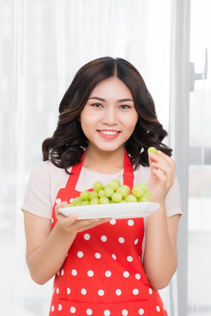 Mooie jonge vrouw met groene druif. Gezond groente eten