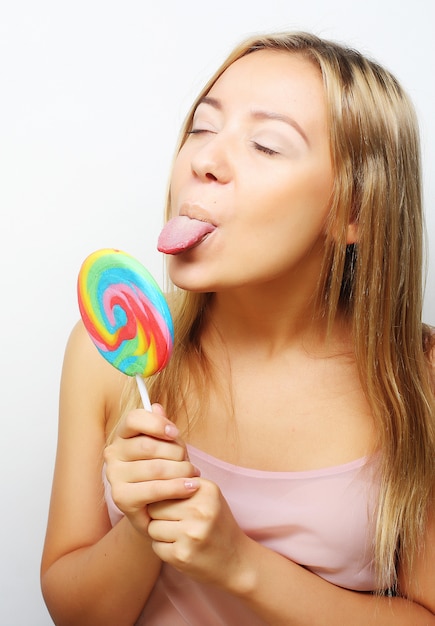 Mooie jonge vrouw met grote kleurrijke lolly