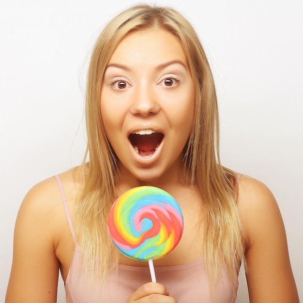 Foto mooie jonge vrouw met grote kleurrijke lolly