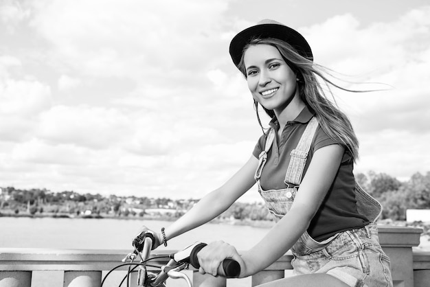 Mooie jonge vrouw met haar fiets in het park