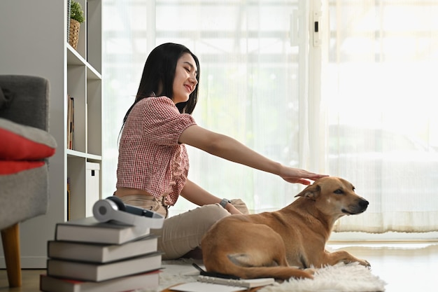 Mooie jonge vrouw met haar schattige hond ontspannen in een gezellig woonkamerinterieur Vriendschapsrelaties beste vriend voor altijd