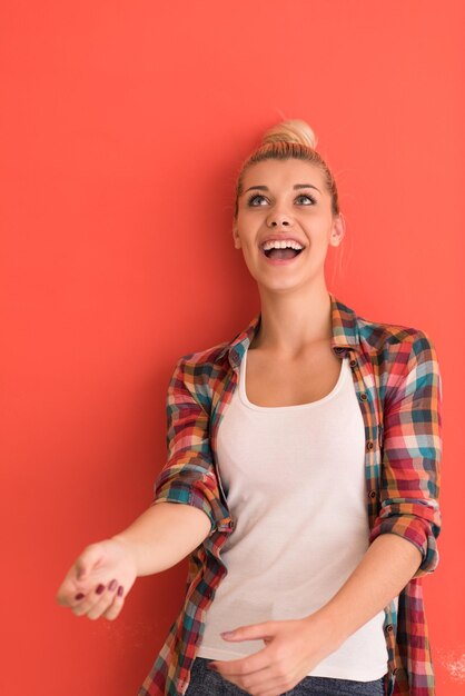 Foto mooie jonge vrouw met haarbroodje speelt met appel over gekleurde achtergrond met copyspace die verschillende emoties uitdrukt