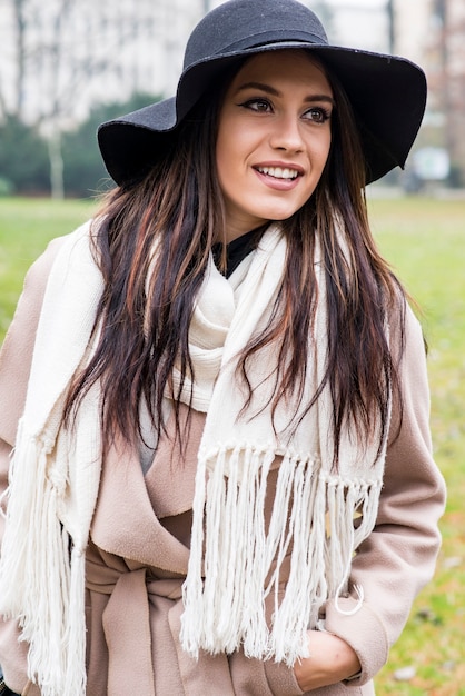 Mooie jonge vrouw met hoed die zich voordeed in het buitenpark