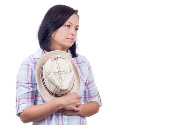 Mooie jonge vrouw met hoed in handen op een witte achtergrond