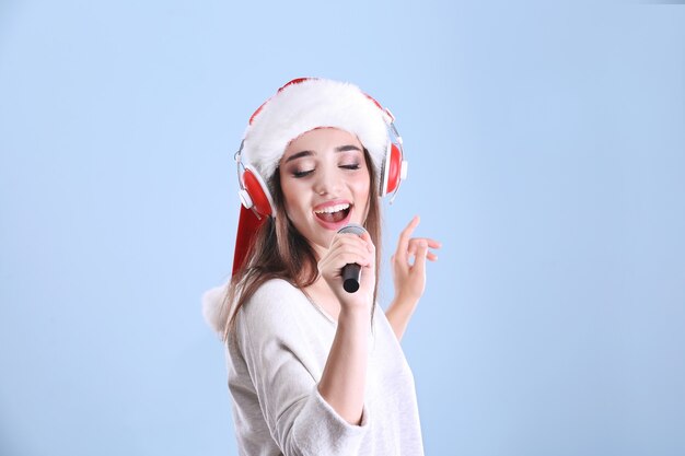 Mooie jonge vrouw met kerstmuts die kerstliedjes zingt