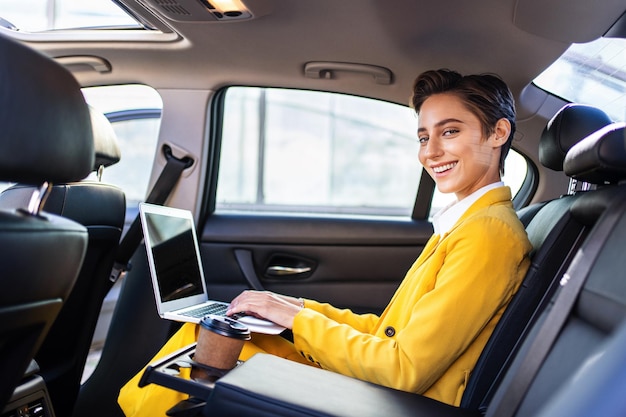 Foto mooie jonge vrouw met kort haar rijdt auto in de stad