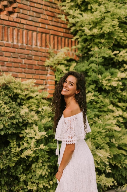 Mooie jonge vrouw met krullend haar in het park