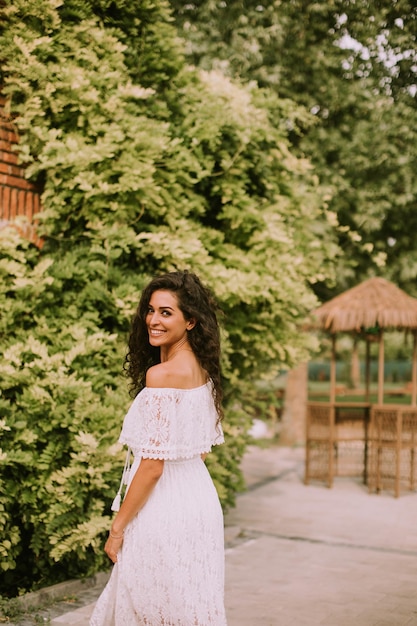 Mooie jonge vrouw met krullend haar in het park