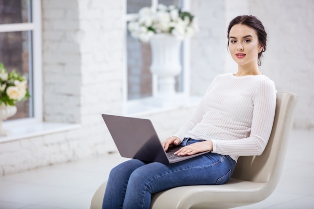 Foto mooie jonge vrouw met laptop binnenshuis