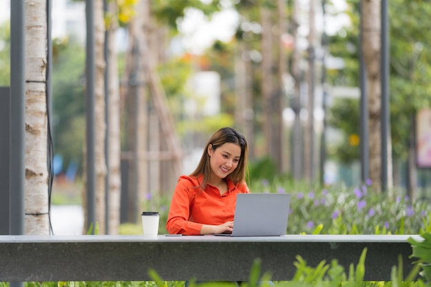 Mooie jonge vrouw met laptop in park