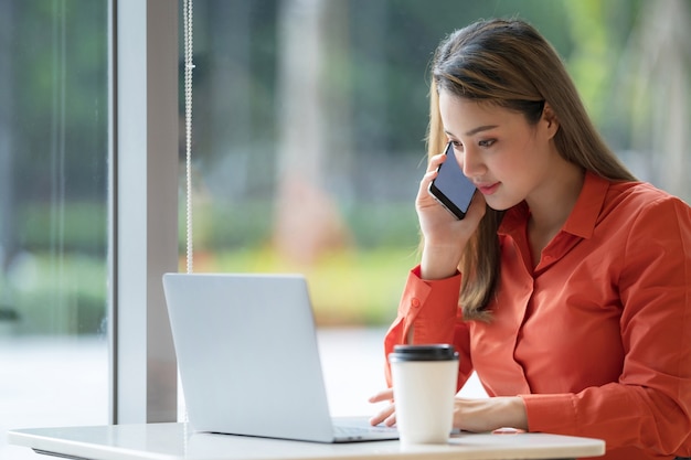 Mooie jonge vrouw met laptop zittend op een koffieshop