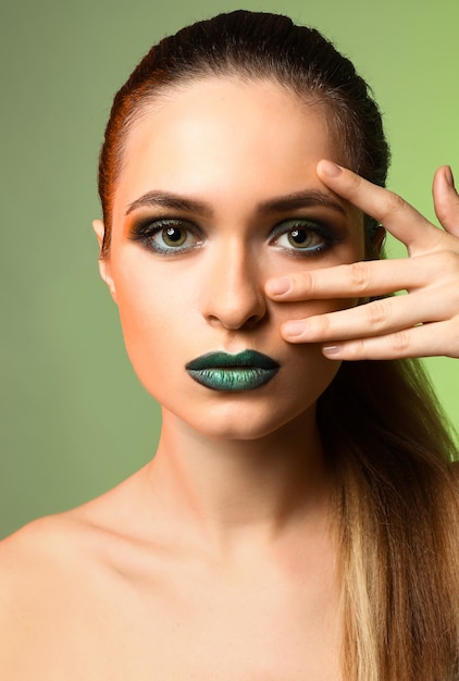 Mooie jonge vrouw met lichte make-up op kleur achtergrond